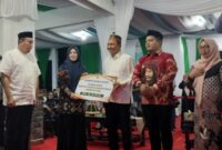 Wakil Gubernur Sulsel, Fatmawati Rusdi, bersama Bupati Luwu Utara, Andi Abdullah Rahim, menyerahkan hadiah kepada juara umum STQH XXIII, Kabupaten Pinrang, di Lapangan Taman Siswa (Tamsis), Masamba, Luwu Utara, pada Sabtu malam, (19/4/2025) (Foto; Istimewa).