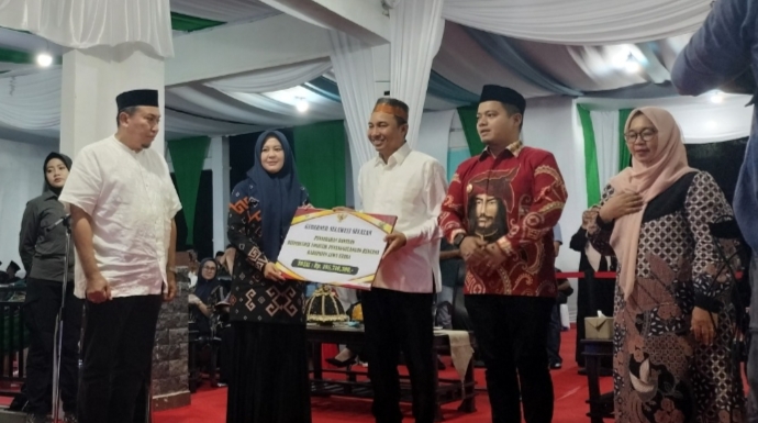 Wakil Gubernur Sulsel, Fatmawati Rusdi, bersama Bupati Luwu Utara, Andi Abdullah Rahim, menyerahkan hadiah kepada juara umum STQH XXIII, Kabupaten Pinrang, di Lapangan Taman Siswa (Tamsis), Masamba, Luwu Utara, pada Sabtu malam, (19/4/2025) (Foto; Istimewa).