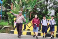 Petugas Satlantas Polres Tana Toraja membantu menyeberangkan siswa di depan sekolah saat kegiatan Strong Point pagi hari, Selasa (22/4/2025) (Foto: Humas).