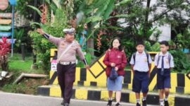 Petugas Satlantas Polres Tana Toraja membantu menyeberangkan siswa di depan sekolah saat kegiatan Strong Point pagi hari, Selasa (22/4/2025) (Foto: Humas).