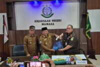 Kepala Kejaksaan Negeri Mamasa, Musa yang menyerahkan Surat Tanda Nomor Kendaraan (STNK) beserta kunci kendaraan, kepada Bupati Mamasa, Welem Sambolangi di dampingi Wakil Bupati Mamasa, Sudirman, di aula kantor kejaksaan negeri Mamasa, Senin (26/5/25).