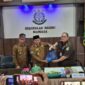 Kepala Kejaksaan Negeri Mamasa, Musa yang menyerahkan Surat Tanda Nomor Kendaraan (STNK) beserta kunci kendaraan, kepada Bupati Mamasa, Welem Sambolangi di dampingi Wakil Bupati Mamasa, Sudirman, di aula kantor kejaksaan negeri Mamasa, Senin (26/5/25).