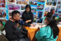 Masyarakat yang sementara memeriksa kesehatan di stand pameran pembangunan Dinas Kesehatan Toraja Utara di alun-alun kota Rantepao, Senin malam (21/7/25). (Dok.Zul/gasingnews.com)