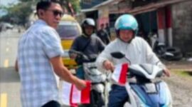 Kasat Intelkam Iptu Desi Salinding membagikan bendera Merah putih kepada pengendara penguna jalan, Rabu (6/8/2025) (Foto: Humas).