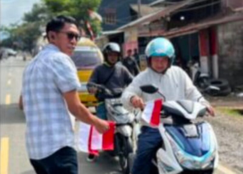 Kasat Intelkam Iptu Desi Salinding membagikan bendera Merah putih kepada pengendara penguna jalan, Rabu (6/8/2025) (Foto: Humas).